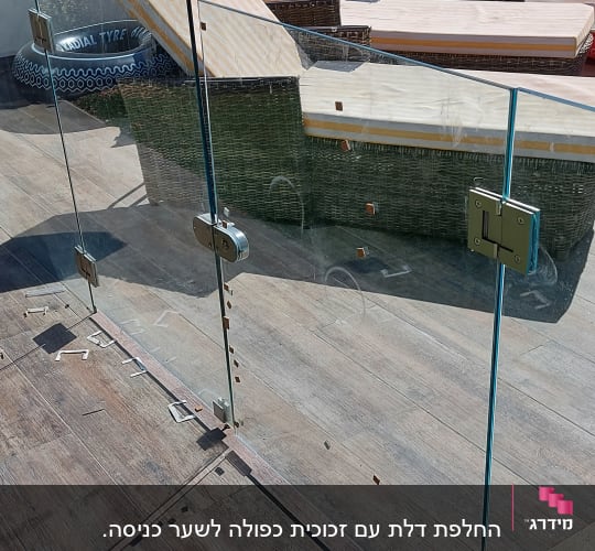 גדר זכוכית עם מחברים מתכתיים על רצפת עץ